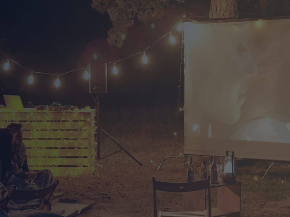 Watching Movie Outdoors on White Screen